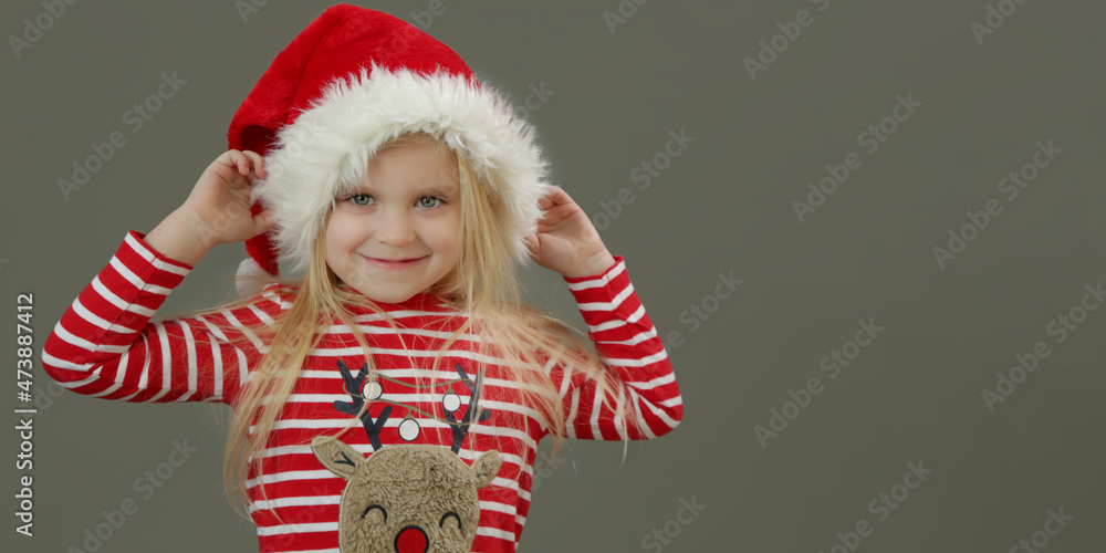 Studio portrait of sweet 4 years old girl in Santa hat and festive Christmas clothes. It's holiday season! Studio portrait of sweet 4 years old girl in Santa hat and festive Christmas clothes. It's holiday season!