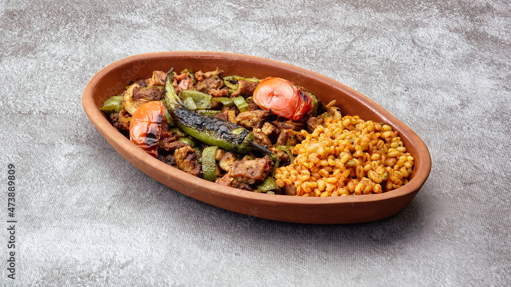 Close up of Turkish chicken Kebab called Mudurnu Kebab, garnished with vegetables, bulgur pilaf served on ceramic dish - Turkish, Food Kebab- Close up of Turkish chicken Kebab called Mudurnu Kebab, garnished with vegetables, bulgur pilaf served on ceramic dish - Turkish, Food Kebab-