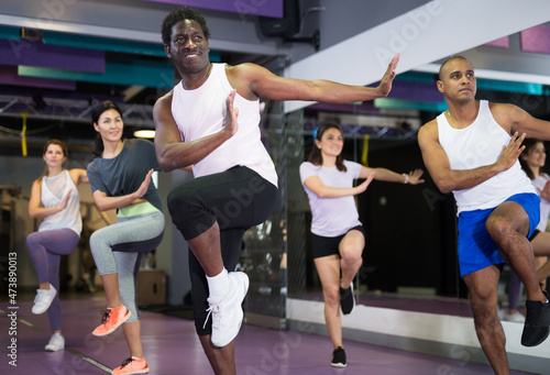 Portrait of excited man dancing during group class in dance center