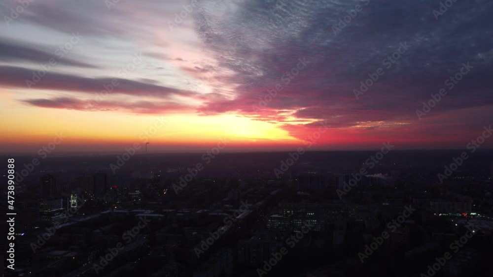 Flying above scenic vivid sunset city with epic vivid cloudscape. Evening Kharkiv city, Pavlove pole residential district streets with evening lights illumination Flying above scenic vivid sunset city with epic vivid cloudscape. Evening Kharkiv city, Pavlove pole residential district streets with evening lights illumination
