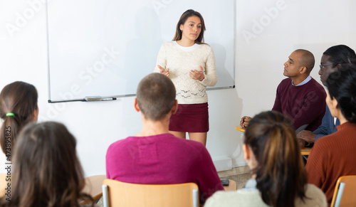 Teacher at university in front of chalkboard with multinational students