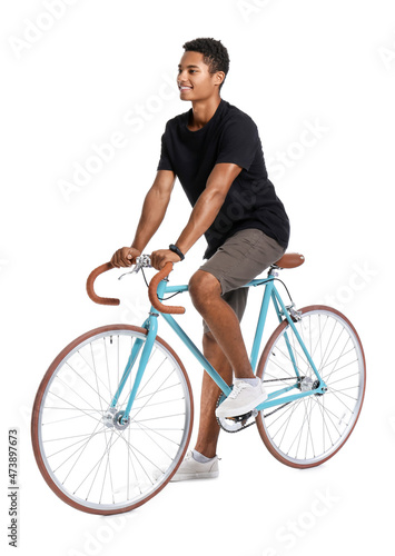 African-American teenage boy riding bicycle on white background