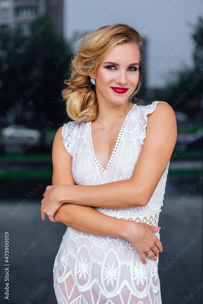 Beautiful blond bride in white wedding dress standing near mirror window outdoors. Beautiful blond bride in white wedding dress standing near mirror window outdoors.