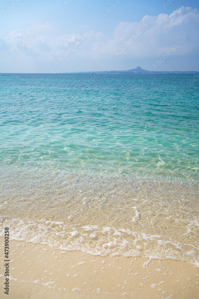 White sandy tropical beach and clear water with blue sky in Okinawa Japan.	