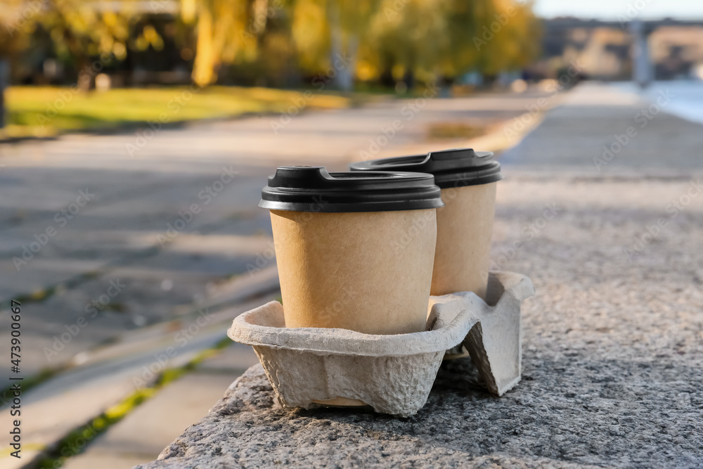 Takeaway cup of tasty latte on parapet outdoors Takeaway cup of tasty latte on parapet outdoors