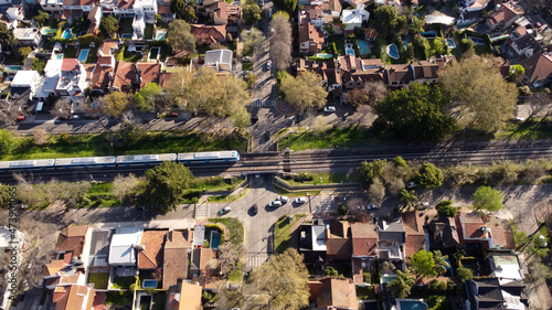 Aerial top down view of a Train in Vicente López residential area Buenos Aires, Argentina. Blue train running through the residential area. photo