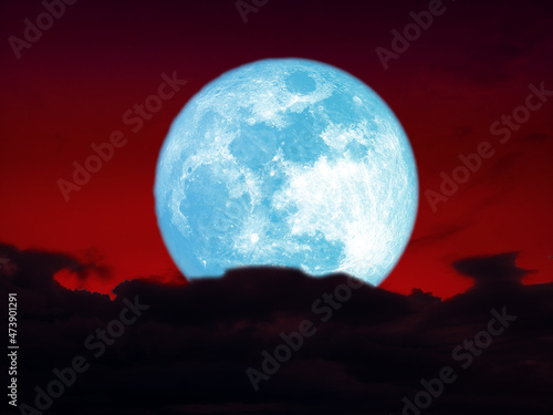full harvest blue moon over dark heap cloud on night red sky