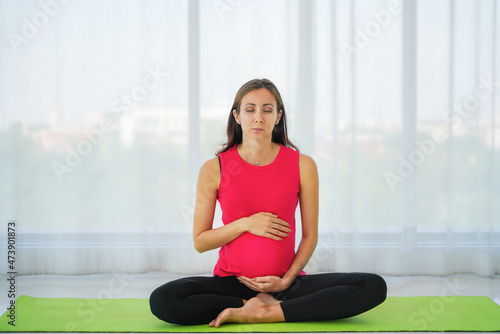 caucasian pregnant woman practicing yoga and meditation