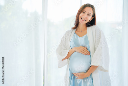 portrait of caucasian pregnant woman standing at home