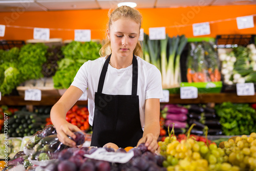 Fotografie Hardworking fifteen-year-old girl who works part-time in a store as a trainee sa