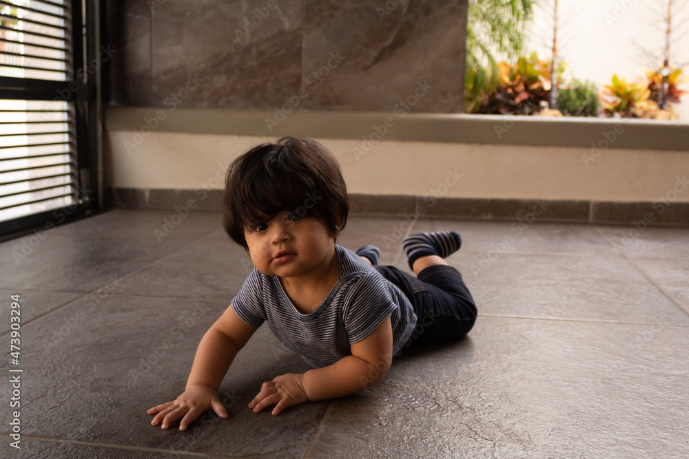 Naklejka premium portrait of a beautiful smiling hispanic baby crawling