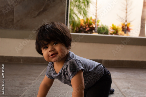 portrait of a beautiful smiling hispanic baby crawling