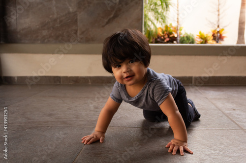 portrait of a beautiful smiling hispanic baby crawling
