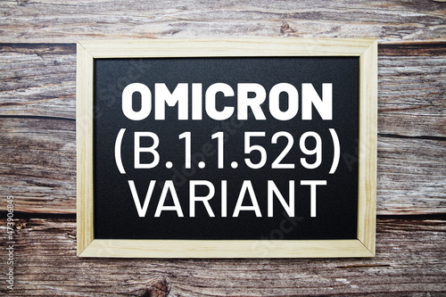 OMICRON Variant text on blackboard flat lay on woodem background