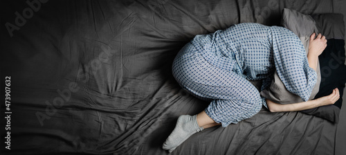Depressed woman lying in bed. Headache