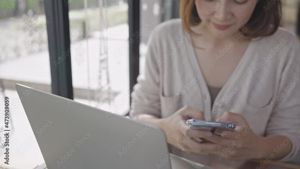 Young woman using smartphone checking social media on the internet in coffee shop, happy smiling. Young woman using smartphone checking social media on the internet in coffee shop, happy smiling.