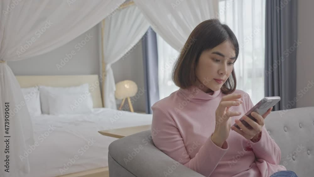 Relaxed young woman using smart phone surfing social media, checking news, playing mobile games or texting messages sitting on sofa. Relaxed young woman using smart phone surfing social media, checking news, playing mobile games or texting messages sitting on sofa.