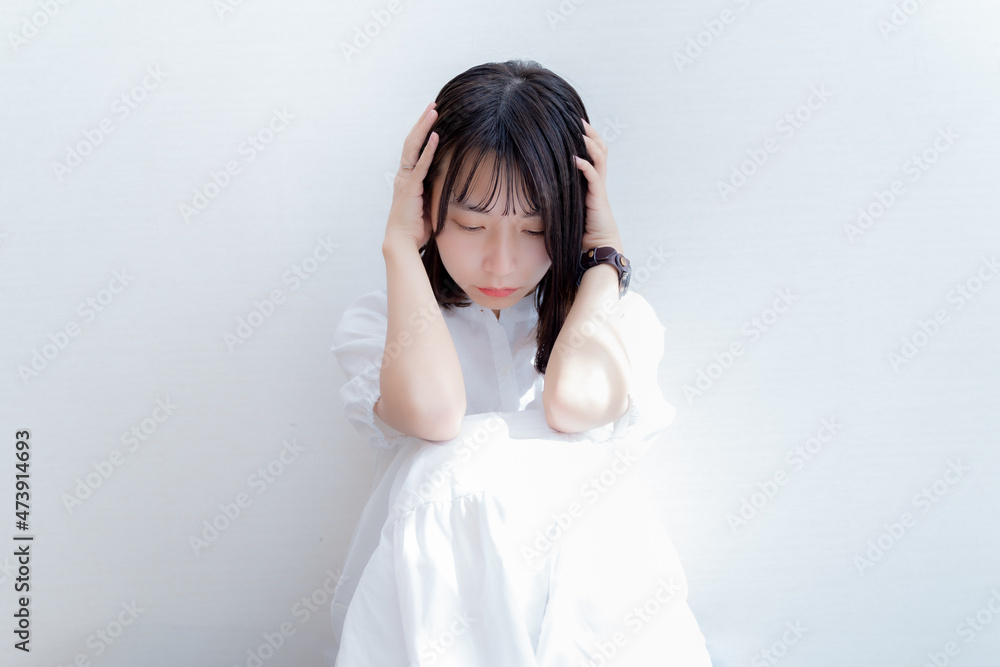 頭を抱えて考え込む女性