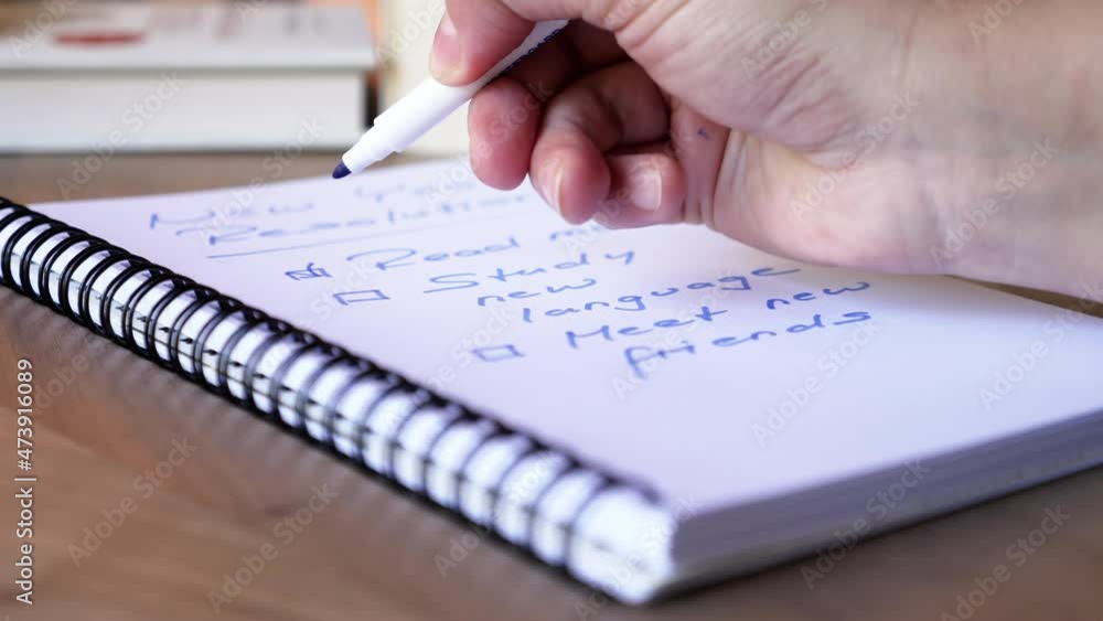 Checking off a list of new year goals and resolutions for personal growth and new perspective in life. Concept for determination and achievement. Checking off a list of new year goals and resolutions for personal growth and new perspective in life. Concept for determination and achievement.