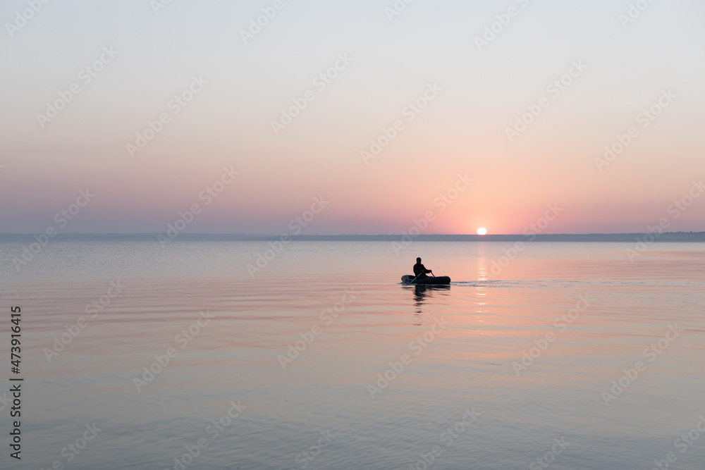 Sea at dawn with fishing rubber boat, calm, Sea of Azov, Russia.