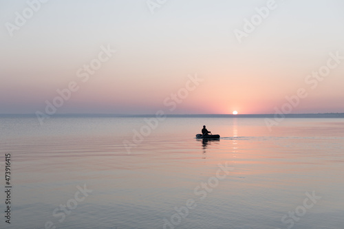 Sea at dawn with fishing rubber boat, calm, Sea of Azov, Russia. © Anastasiia
