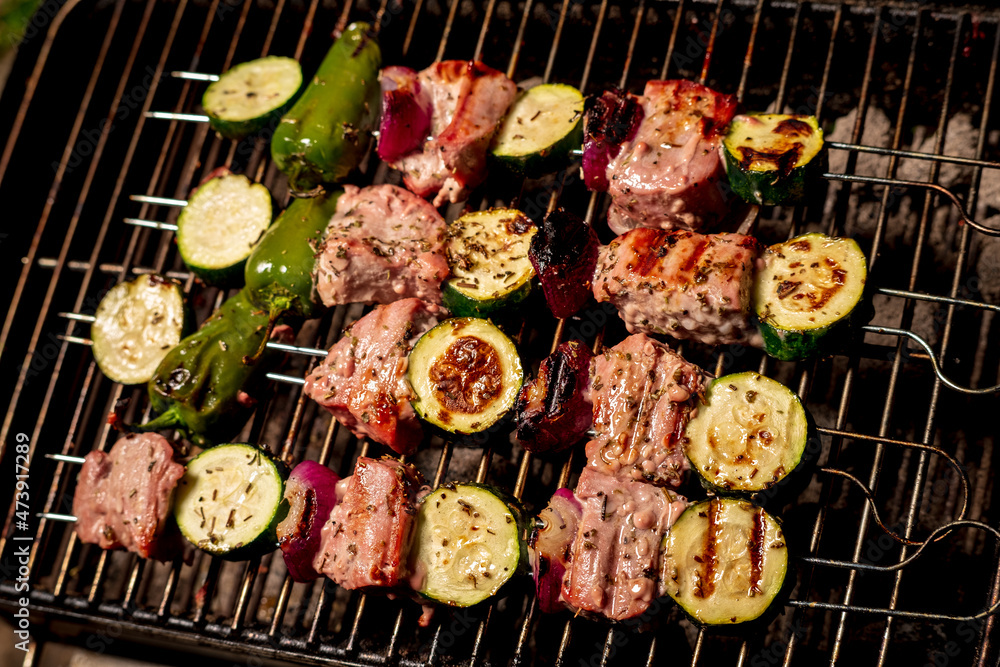 Close up of delicious pork on wooden skew with fresh vegetables Close up of delicious pork on wooden skew with fresh vegetables