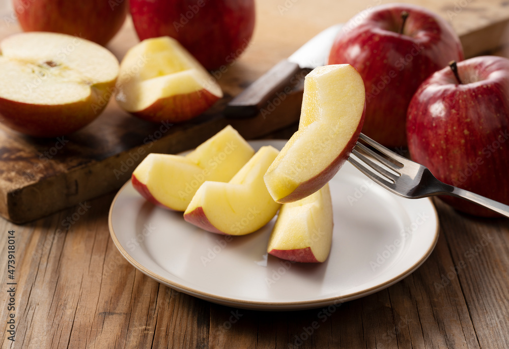 Cut apples on a plate against a wooden background. Cut apples on a plate against a wooden background.