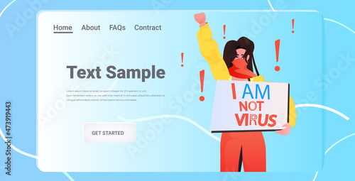 stop asian hate woman in mask holding banner against racism support people during coronavirus pandemic