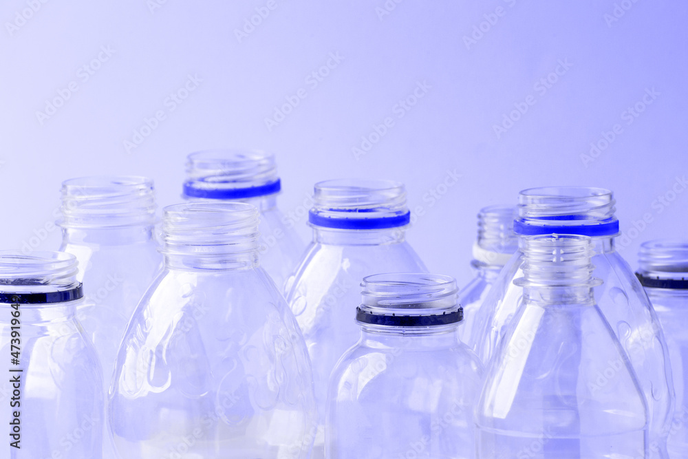 Set of diverse used empty water plastic bottles without caps on pastel pink background. Concept of recycle plastic pakaging, reuse industry, zero waste, eco-friendly Set of diverse used empty water plastic bottles without caps on pastel pink background. Concept of recycle plastic pakaging, reuse industry, zero waste, eco-friendly