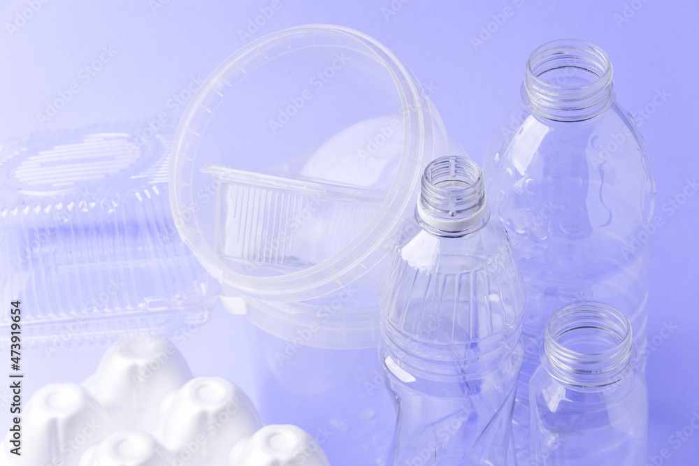 Set of diverse used empty water plastic bottles without caps on purple violet trendy background. Concept of recycle plastic pakaging, reuse industry, zero waste, eco-friendly, color of year 2022 Set of diverse used empty water plastic bottles without caps on purple violet trendy background. Concept of recycle plastic pakaging, reuse industry, zero waste, eco-friendly, color of year 2022