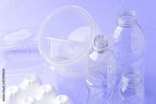 Set of diverse used empty water plastic bottles without caps on purple violet trendy background. Concept of recycle plastic pakaging, reuse industry, zero waste, eco-friendly, color of year 2022