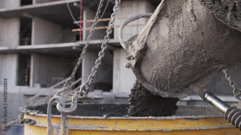 concrete pours from a concrete mixer at a construction site concrete pours from a concrete mixer at a construction site
