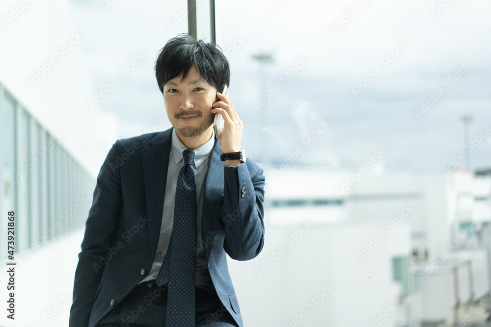スーツ　ビジネス、男性　人物　携帯　スマホ　電話　