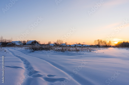 Village on a sunny morning and snowy field
