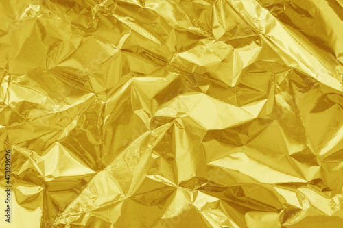 Shiny gold foil texture background  pattern of yellow wrapping paper with crumpled and wavy.
