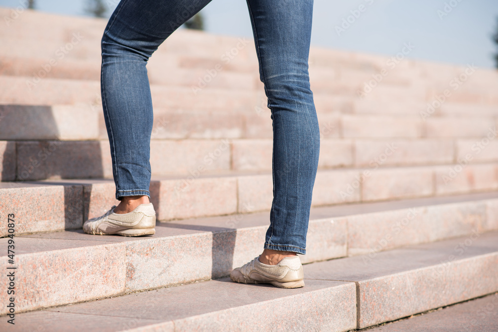 Close up of female legs climbing the steps up.