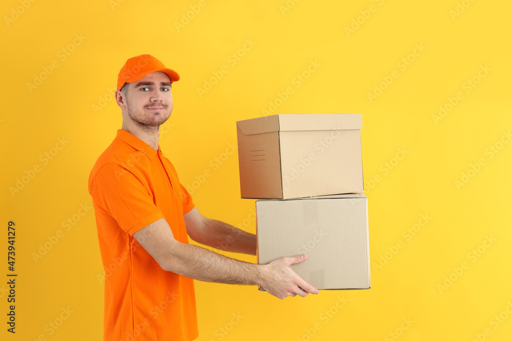 Delivery guy hold boxes on yellow background Delivery guy hold boxes on yellow background