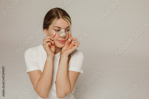 A young woman with a bandage on her nose after rhinoplasty photo