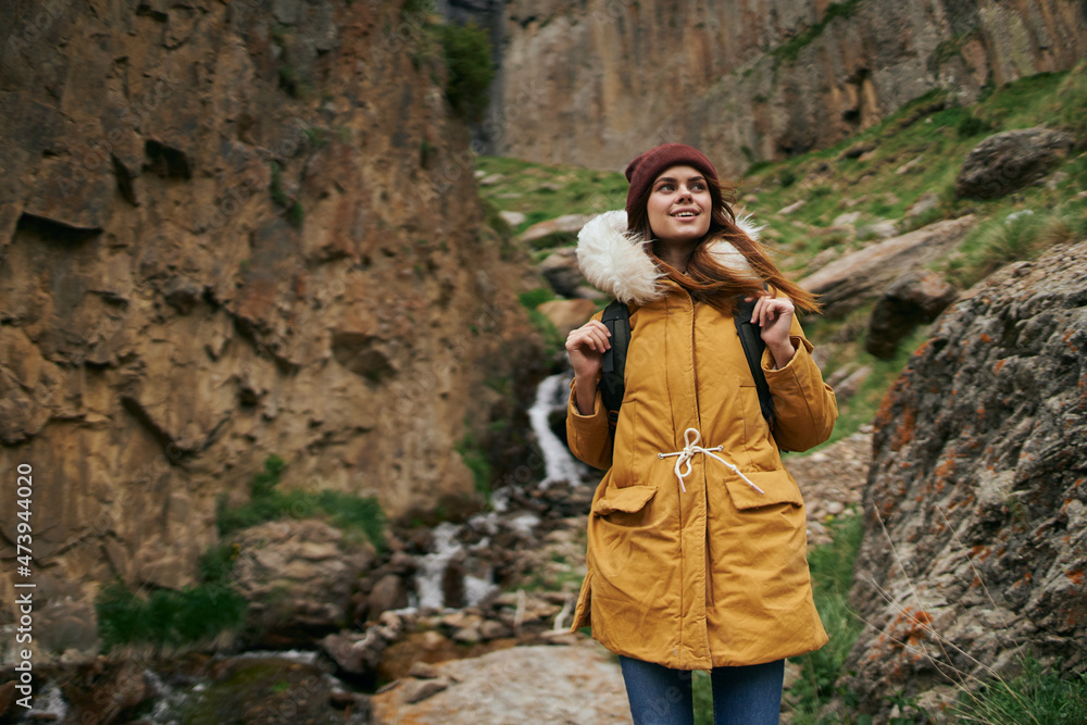woman in yellow jacket hiking in the mountains travel adventure