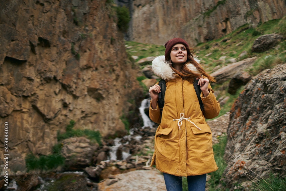 Naklejka premium woman in yellow jacket hiking in the mountains travel adventure