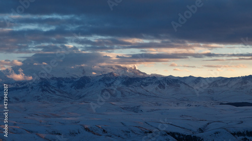 Elbrus in the clouds in the light of the sunset rays © Aleksandr