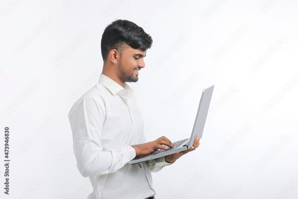 Young indian man using laptop over white background. Young indian man using laptop over white background.