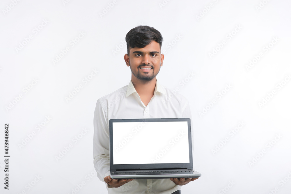 Young indian man showing laptop screen with copy space on white background. Young indian man showing laptop screen with copy space on white background.