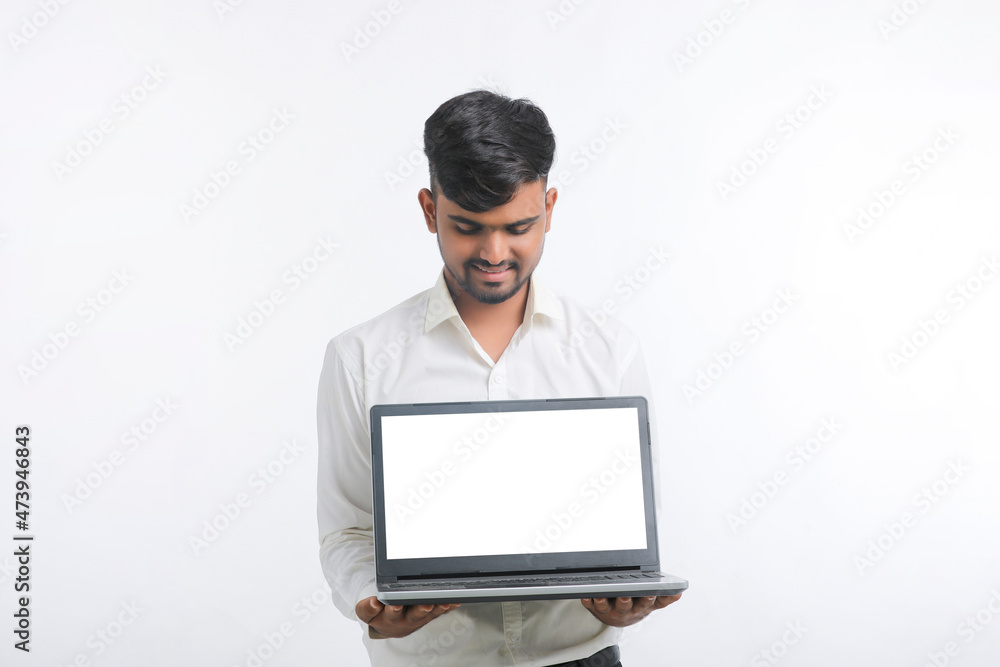 Young indian man showing laptop screen with copy space on white background. Young indian man showing laptop screen with copy space on white background.