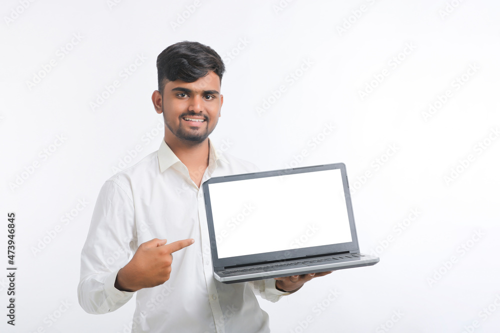 Young indian man showing laptop screen with copy space on white background.