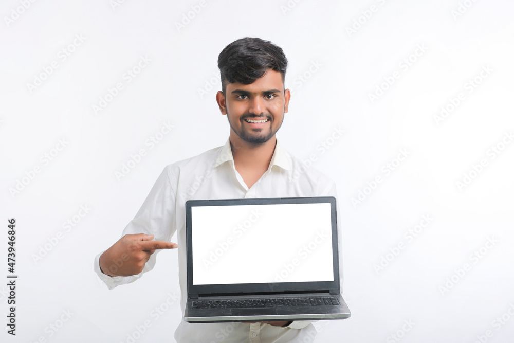 Young indian man showing laptop screen with copy space on white background. Young indian man showing laptop screen with copy space on white background.