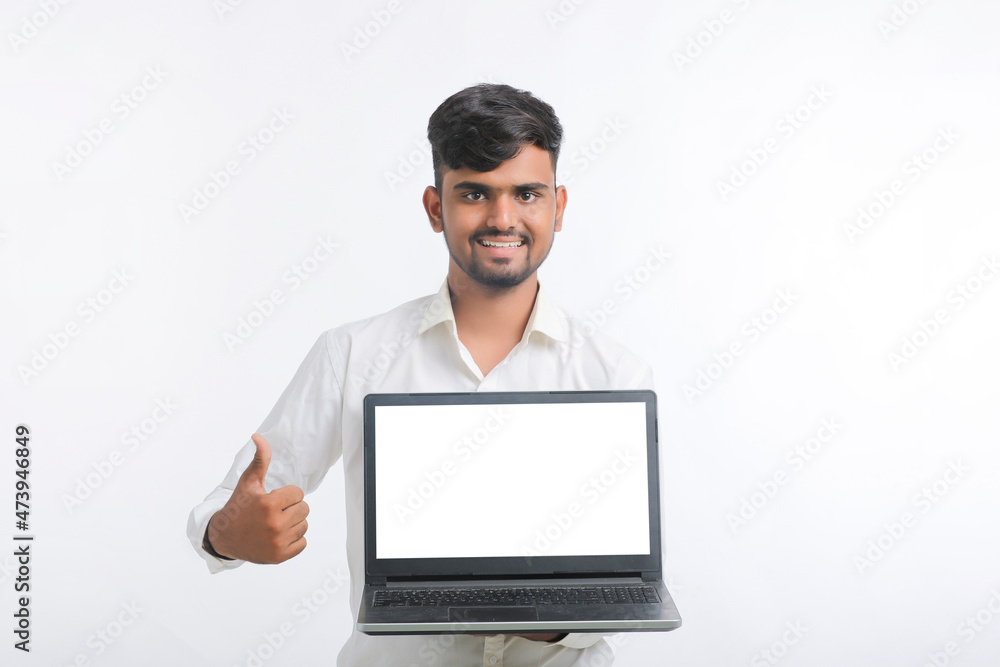Young indian man showing laptop screen with copy space on white background. Young indian man showing laptop screen with copy space on white background.