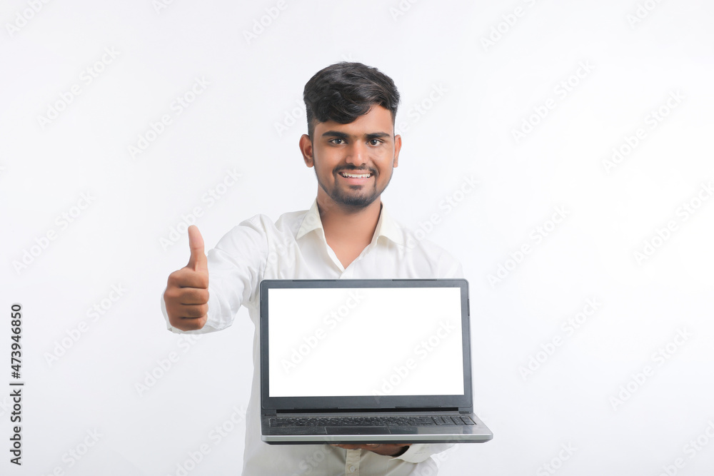 Young indian man showing laptop screen with copy space on white background. Young indian man showing laptop screen with copy space on white background.