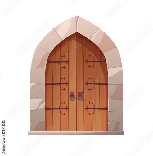 Antique medieval wooden door with metal round handle and lined with stones. Gothic entrance, gate in a castle, church or house.