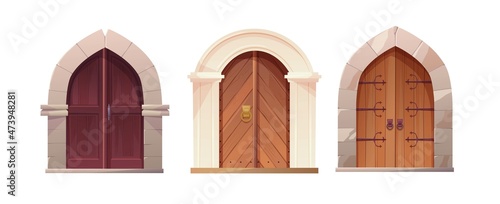 Antique medieval wooden door with metal round handle and lined with stones. Gothic entrance, gate in a castle, church or house.